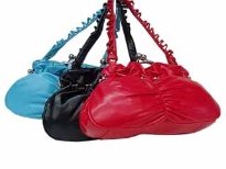 Fashionable shoulder bag has a ruched detail along center, a detailed shoulder strap, and a kiss lock. Made of faux leater.