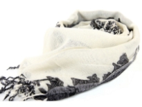 Off-white scarf with black colored floral 7 paisley print on it. Hanging twisted fringe at the edges. Imported. Dry clean only. 100% wool.