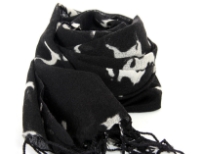 Different abstract animals in white color of all sizes are running over this black wool scarf framed with long twisted fringe. Imported. Dry clean only.