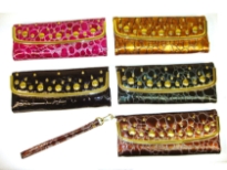 Studded wristlet has a metallic texture, animal print pattern, a magnetic closure and a detachable strap. Made of faux leather.