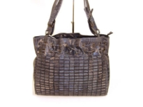 Crinkled look huge shoulder bag has double handle with adjustable belt. Zipper closure on top. Bag has a drawstring closure. Made of PVC.