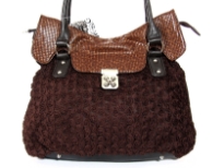 Shoulder bag is adorned with abstract fabric mini roses, has a double handle, top zipper closure and an elegant twist lock closure. Made of PVC.