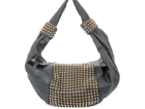 Faux Leather Studded Shoulder bag. This one piece bag has golden studs in the middle of the bag as well as on single shoulder strap. Top zipper closure.