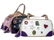 Designer Inspired Handbag has embellished letters, top zipper closure, and a double handle. Made of faux leather.