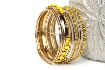 This gold colored metal 9 pieces set can be matched with any kind of outfit during day or at night. Set includes 6 plain thin bangles, 2 similar round beads bangles & one wide metal pattern bangle with yellow beads. 