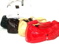 PVC Handbag has a top zipper closure and a single strap. Small diamond details along center. 