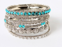 Beautifully hand crafted silver colored set of 8 fashion bangles in assorted widths & pattern. Each has its own metal pattern with one wide bangle having colored mirrors & also one thin bangle with colored mirrors. Expert craftsmanship reflects through this stylish set.