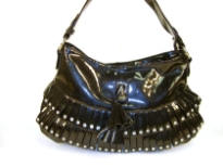 Fashion shoulder bag has a top zipper closure, a single strap and layered frill in same fabric with studs on them. Made of PVC.