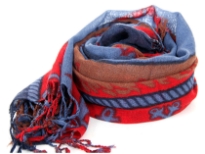 Nautical symbology floats over this 100% wool scarf in blue, red & brown colors. The scarf has boats & anchors print with fringes at the ends. Hand wash. Imported.