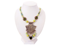This queenly vintage look necklace has engraved brass tone metal pendant with different shapes of hanging resin beads in shades of lime green & green. Same beads are also on the string which has multiple satin threads in shades of green at the ends. Imported.