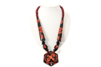 Chunky look black resin necklace with orange carved pattern. Hexagon shape drop pendant gives it a little tribal look. Imported.