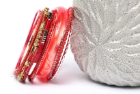 This assorted bangles set in coral color has 12 pieces including 1 resin bangle in bronze colored metal frame, 1 broad resin bangle & 10 thin resin bangles in different patterns. Can be worn all together as a set or individually. Hand crafted.