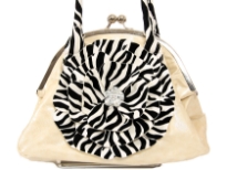 Shining PVC Handbag with zebra print double handle & cut out flower applique at front. Kiss lock closure of the bag. Imported.